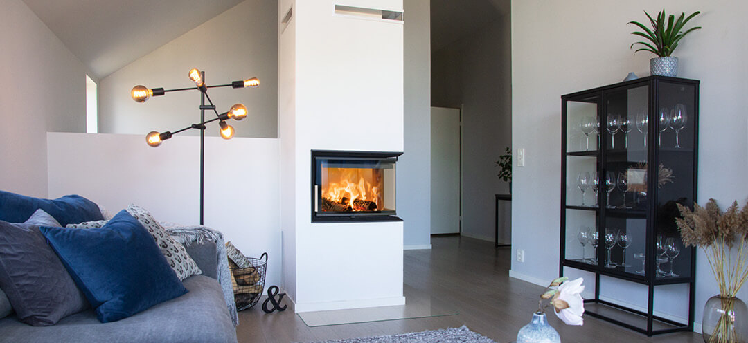 White corner fireplace Scan 5003 FR with flames in white modern home with gray sofa and round table
