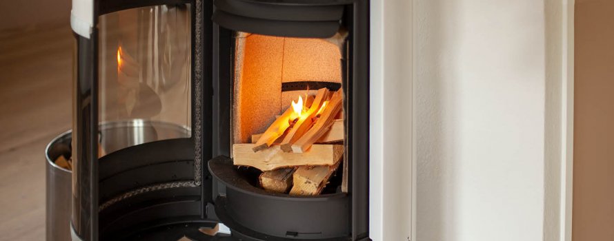 White wood-burning stove Scan 83-2 with open door and fire that is lit