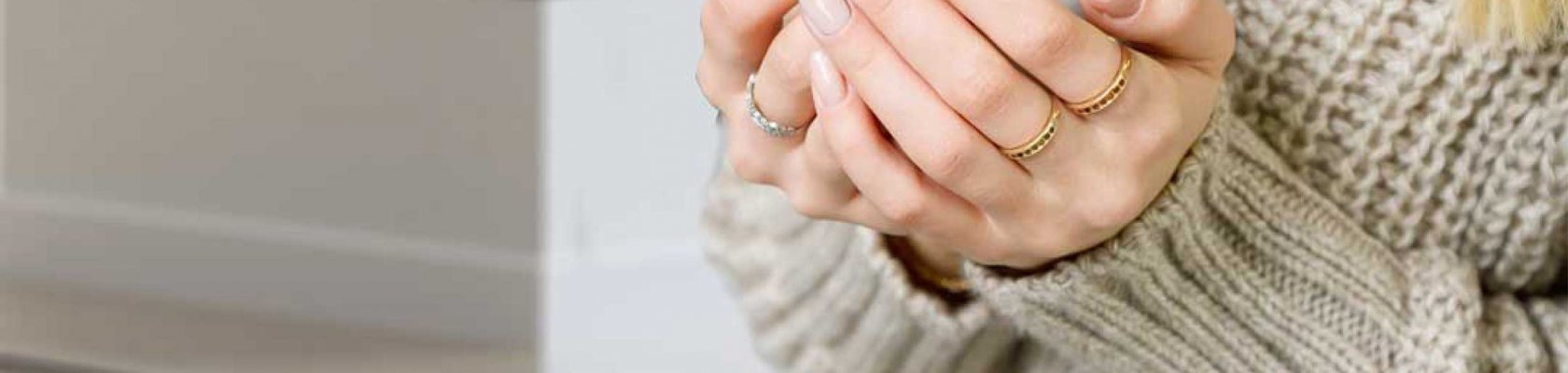 Lady with beige sweater holding white cup with diffused fireplace Scan 5005 FRL in the background