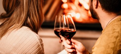 Couple drinking wine in front of the fireplace