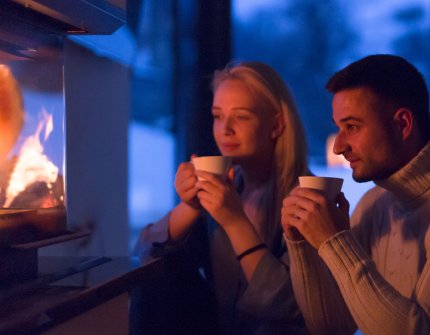 Couple drinking cocoa in front of the fireplace