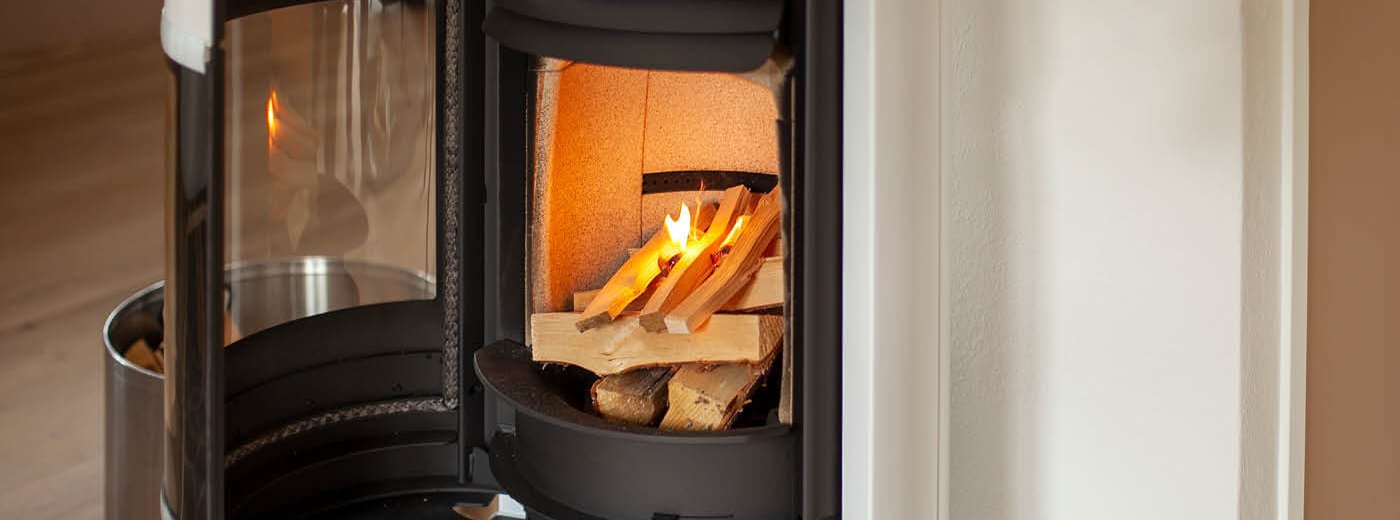 White wood-burning stove Scan 83-2 with open door and fire that is lit