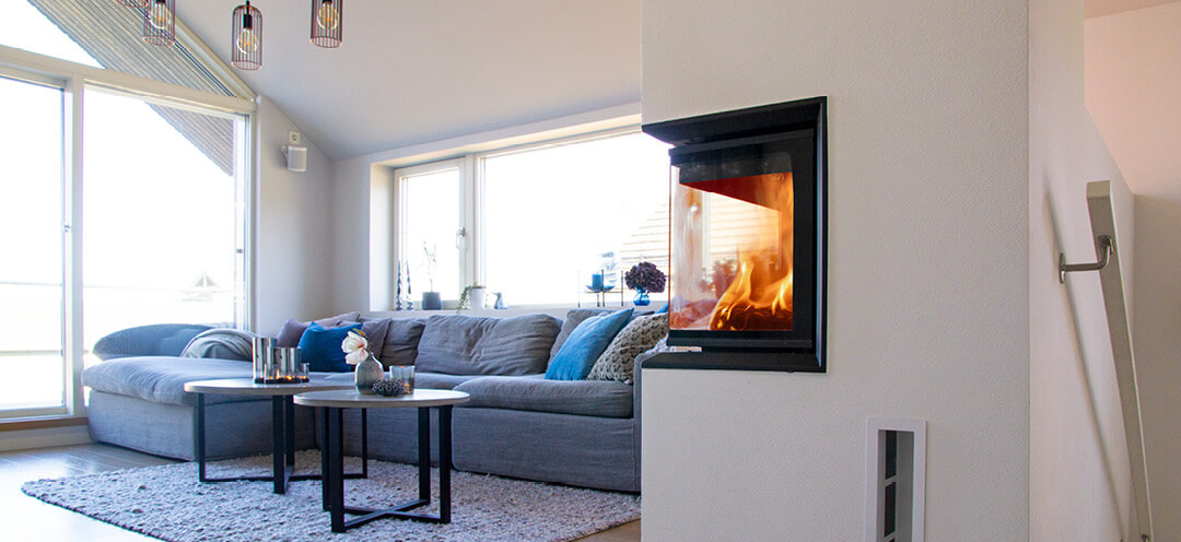 Large white fireplace with glass on two sides Scan 5003 FR in a modern living room with a blue sofa