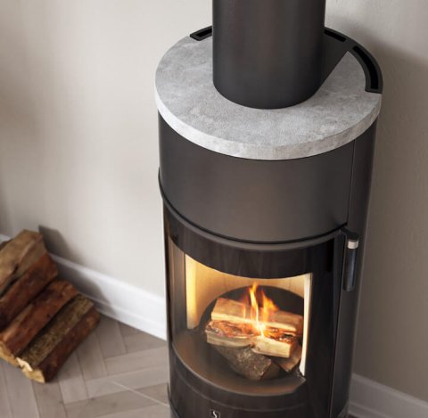 Black fireplace with soapstone top in bright room with wood on the left